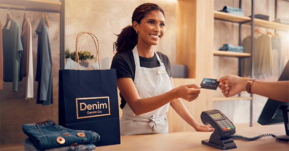 retail store employee receiving payment from customer on co-branded card