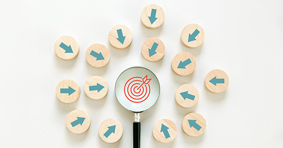 multiple arrows pointing at magnifying glass over target