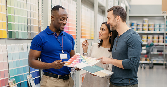 home improvement store frontline employee assisting couple with paint samples