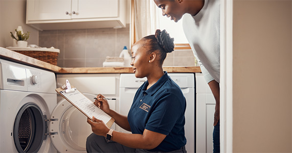 home service and support technician helping customer with washing machine repair