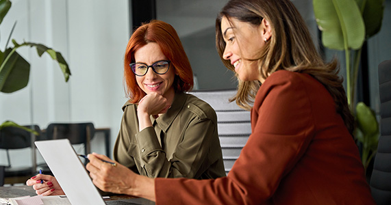 sales team reviewing documents on laptop