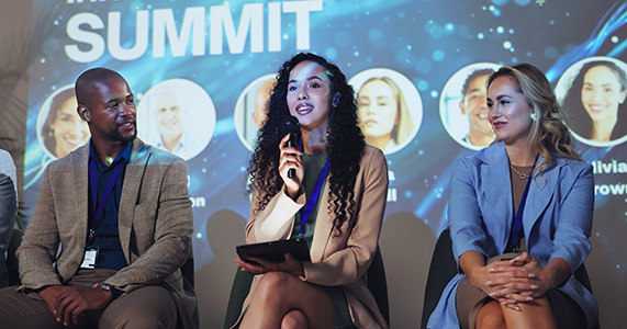 panelists on stage speaking at event