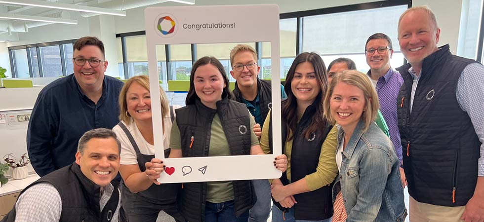 employees celebrating work anniversary with photo props